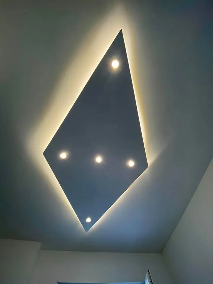 Controsoffitto a forma di rombo con faretti incassati e luce calda nascosta lungo il perimetro
