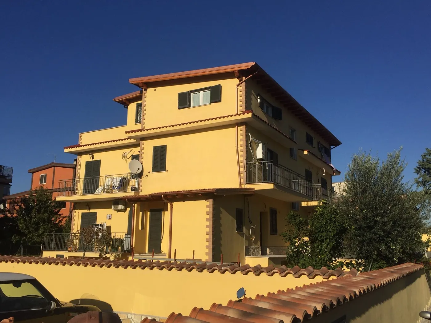 Palazzina di tre piani costruita da FGF Costruzioni, facciata gialla con balconi e tetto in coppi
