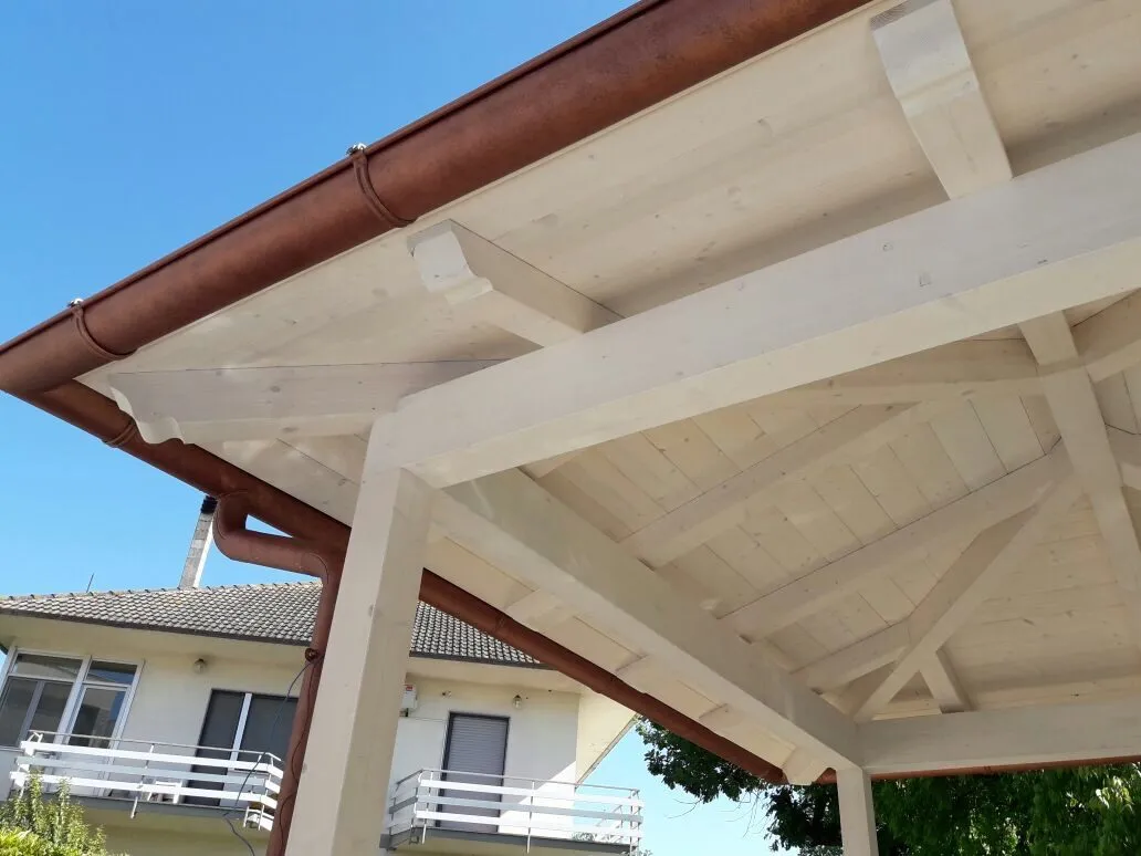 Pergolato in legno bianco con gronda in rame realizzato su una copertura residenziale