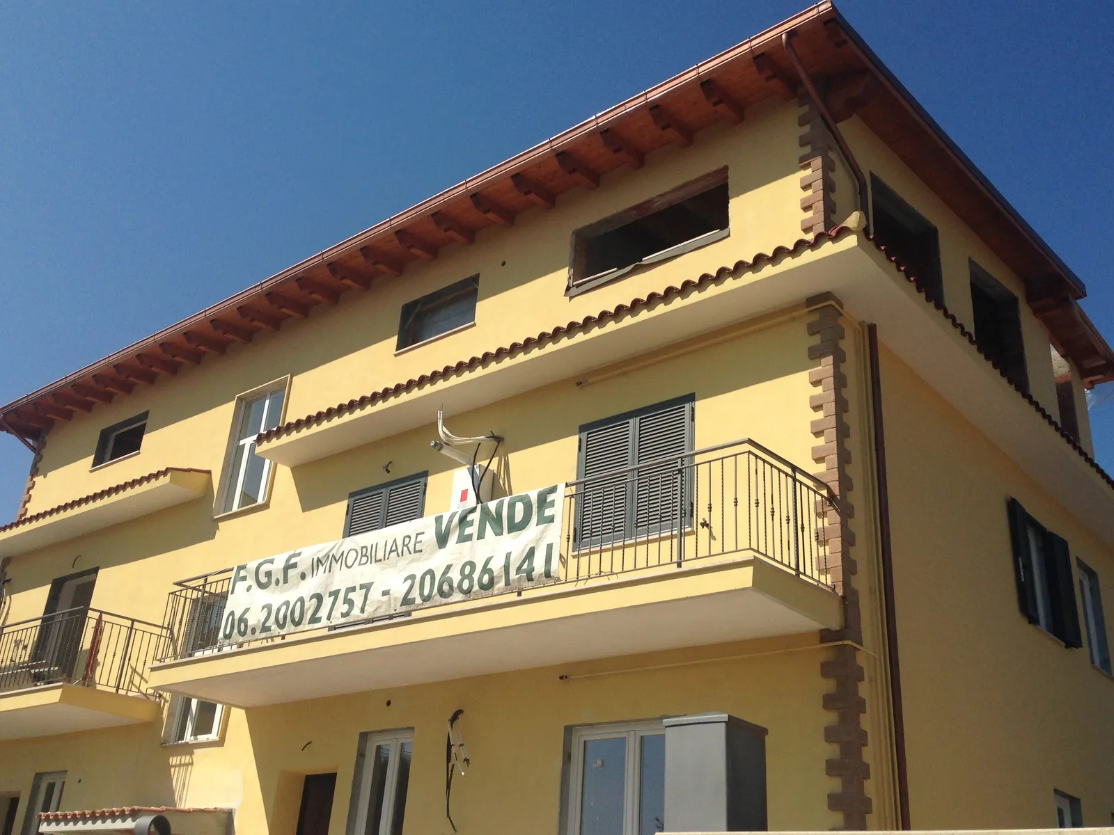 Palazzina residenziale a Roma est con l'insegna di vendita di FGF Immobiliare sul balcone
